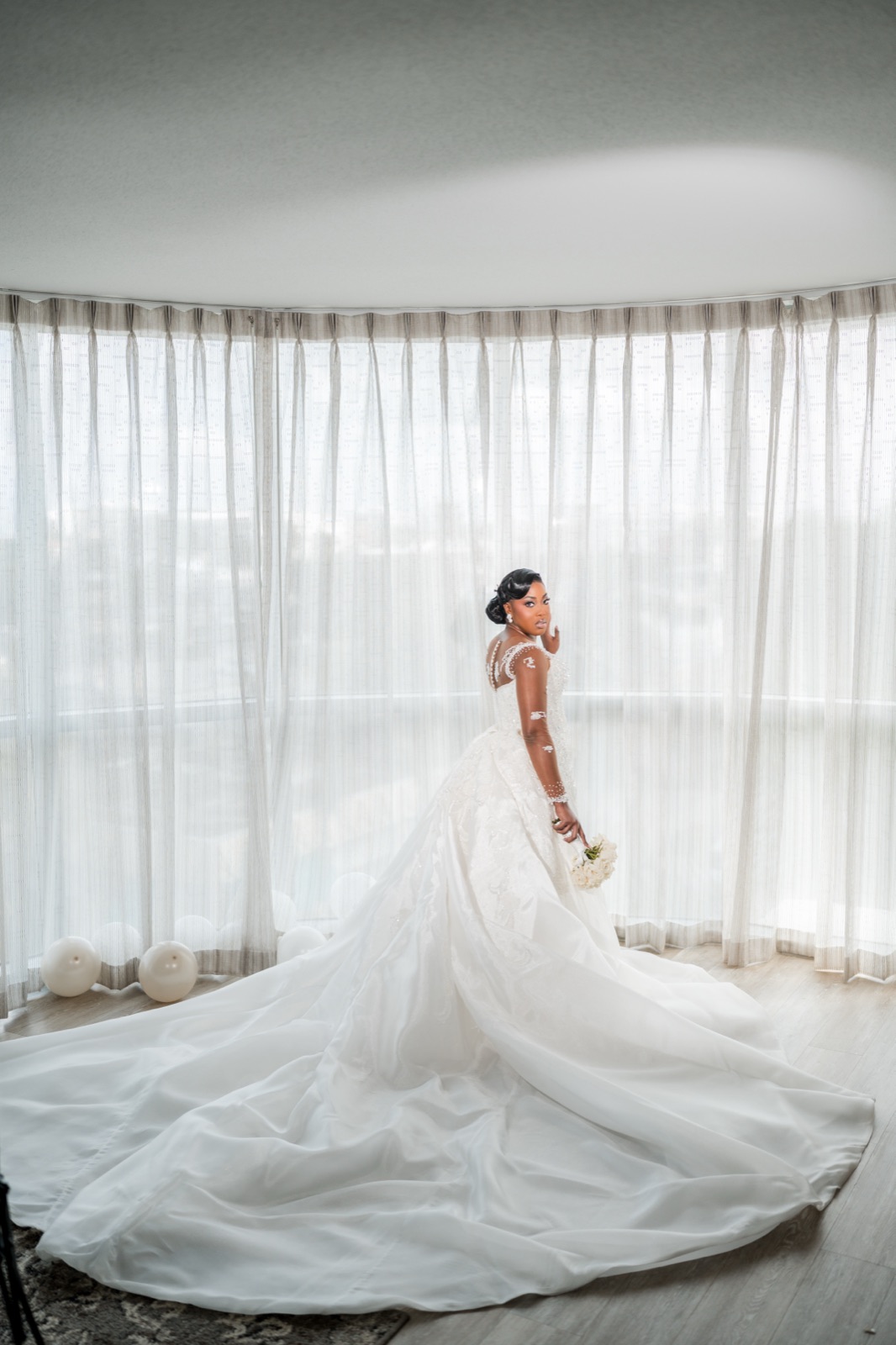 Bride with a sweeping train in a sunlit round room