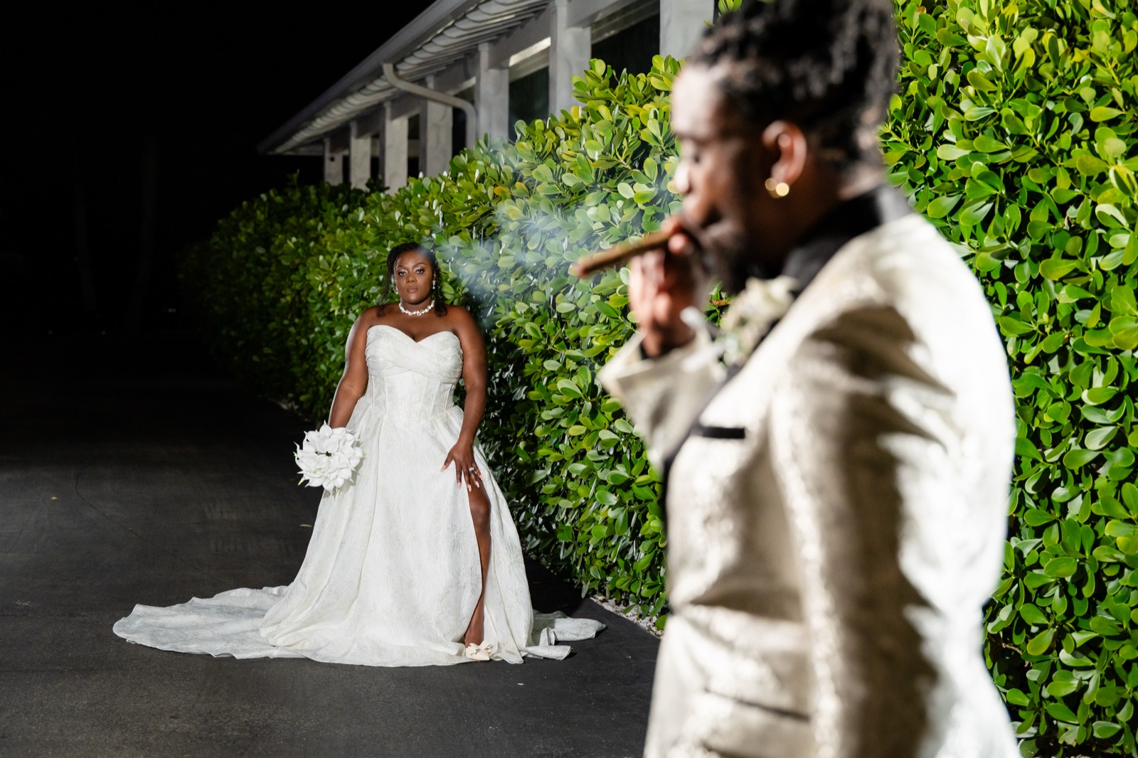 Couple portrait against a lush greenery wall