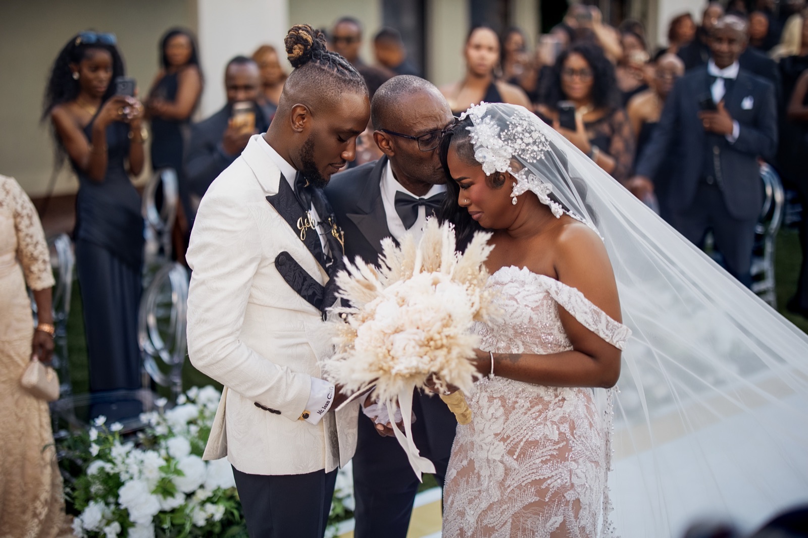 Bride and groom celebrating in the aisle surrounded by guests